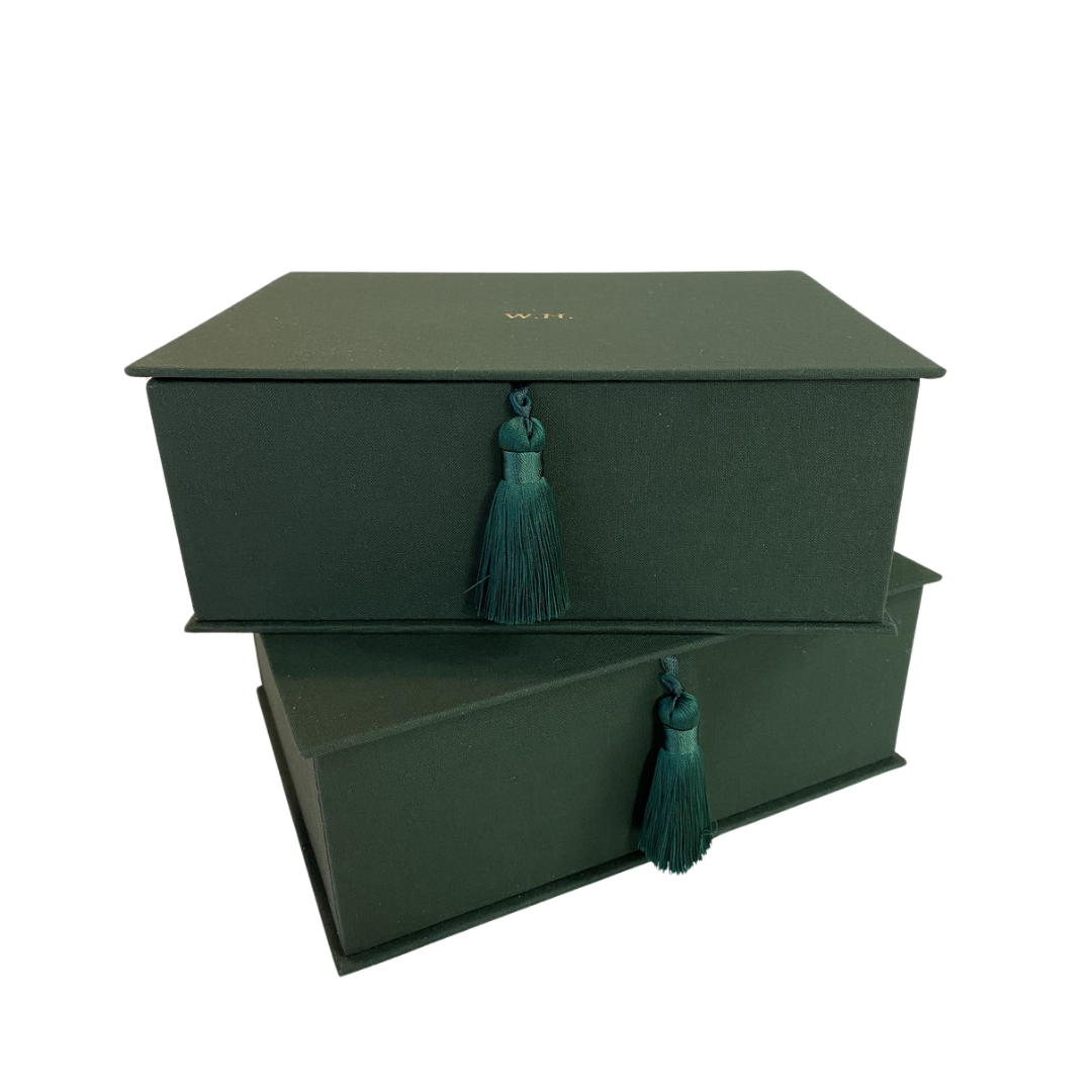 Mit Goldprägung personalisierte Aufbewahrungsbox für Bridge-Zubehör zum Aufklappen mit dunkelgrünem Stoff überzogen, zwei Boxen übereinander gestapelt, aufgenommen in der Dreiviertelansicht.