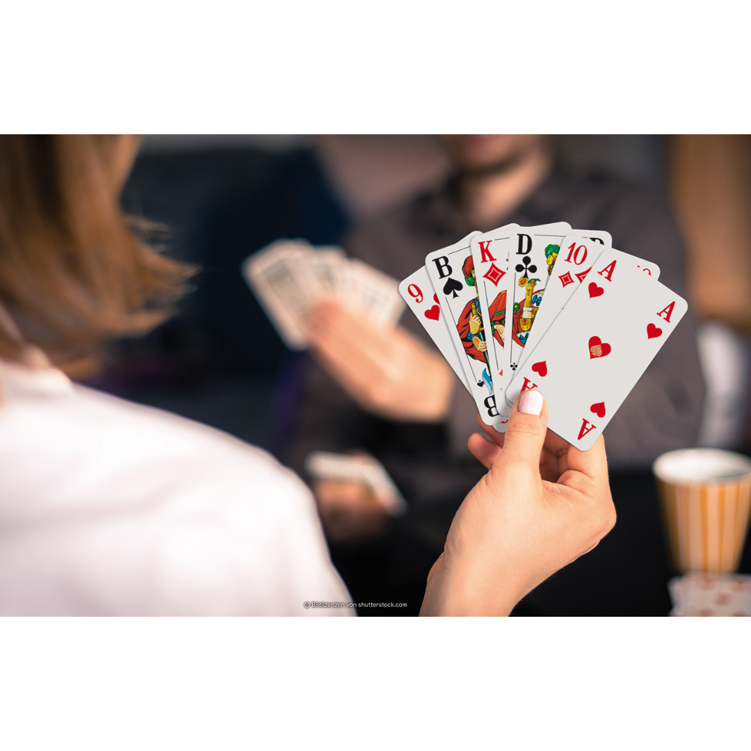 Eine Hand hält einen Kartenfächer mit den ASS Senioren-Spielkarten Doppelkopf.
