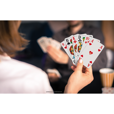 Eine Hand hält einen Kartenfächer mit den ASS Senioren-Spielkarten Doppelkopf.