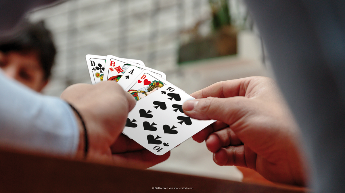 Eine Hand hält einen Kartenfächer mit den ASS Altenburger Skat Spielkarten.