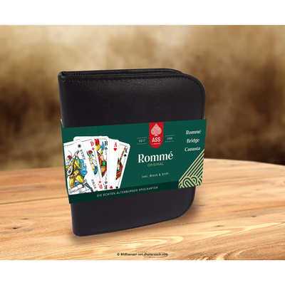 Schwarzes Spielkarten-Etui aus Kunstleder mit Papp-Banderole für ASS Spielkarten Rommé auf einem Holztisch